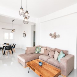 Bright and spacious living room with modern decor at Villa Aegean Colors in Tinos.