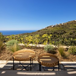 Βεράντα της Villa Erato με εξωτερική τραπεζαρία και μαγευτική θέα στο Αιγαίο.