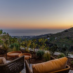 Βεράντα της Villa Erato με εξωτερική τραπεζαρία και μαγευτική θέα στο Αιγαίο.