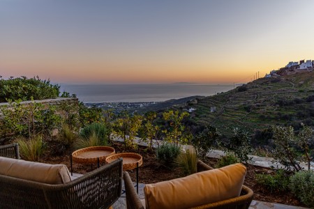 Βεράντα της Villa Erato με εξωτερική τραπεζαρία και μαγευτική θέα στο Αιγαίο.