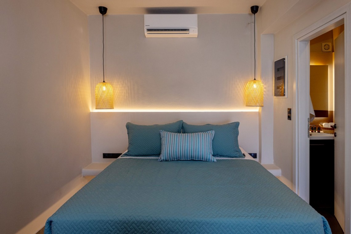 Υπνοδωμάτιο της Blue Pearl Suite με μοντέρνα αισθητική και ανοιχτή ντουλάπα.