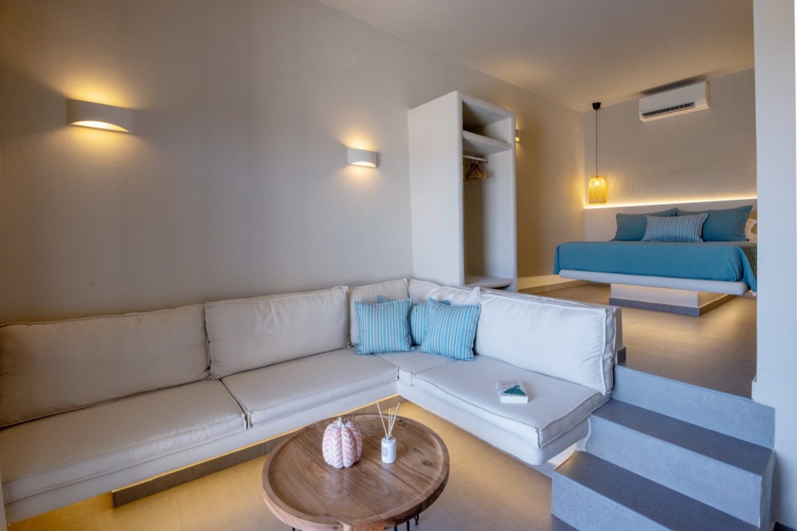 Άνετος και κομψός χώρος καθιστικού στη Blue Pearl Suite με φυσικό φωτισμό.