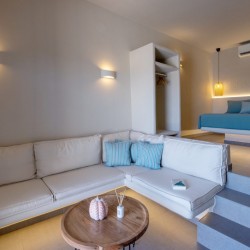 Άνετος και κομψός χώρος καθιστικού στη Blue Pearl Suite με φυσικό φωτισμό.