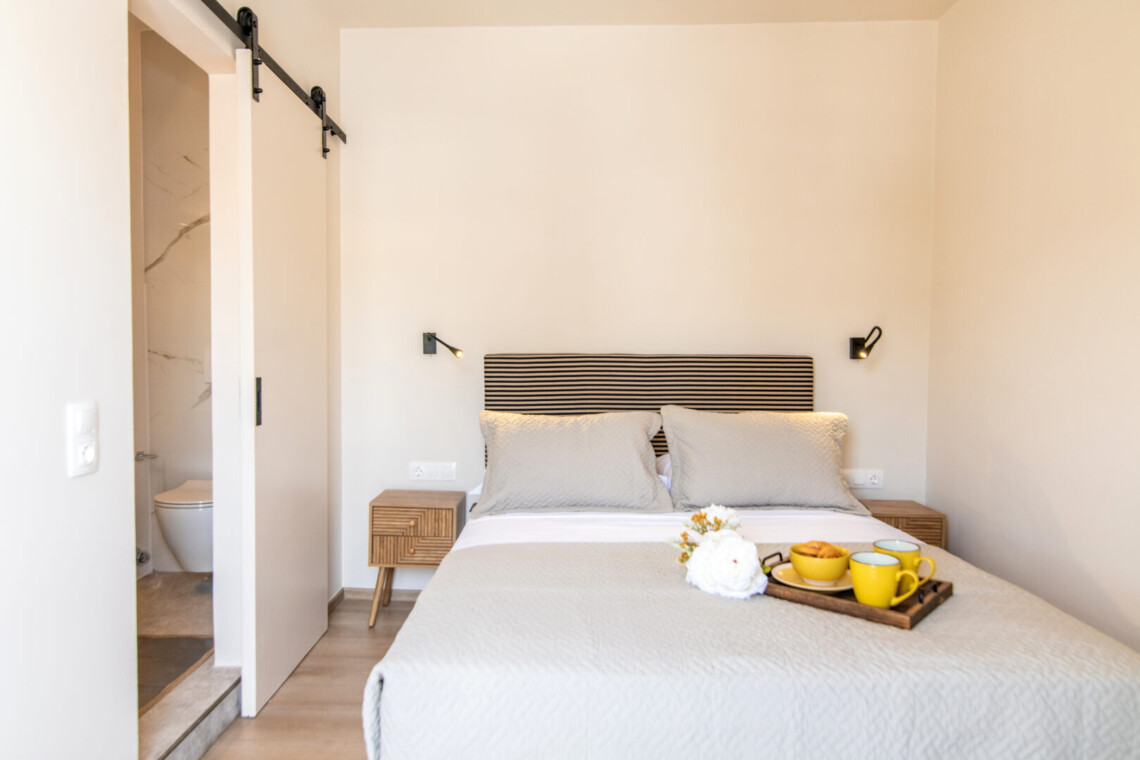 Comfortable queen-size bed in the one-bedroom suite at Local Living House, providing a relaxing retreat in Tinos Town.