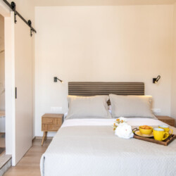 Comfortable queen-size bed in the one-bedroom suite at Local Living House, providing a relaxing retreat in Tinos Town.