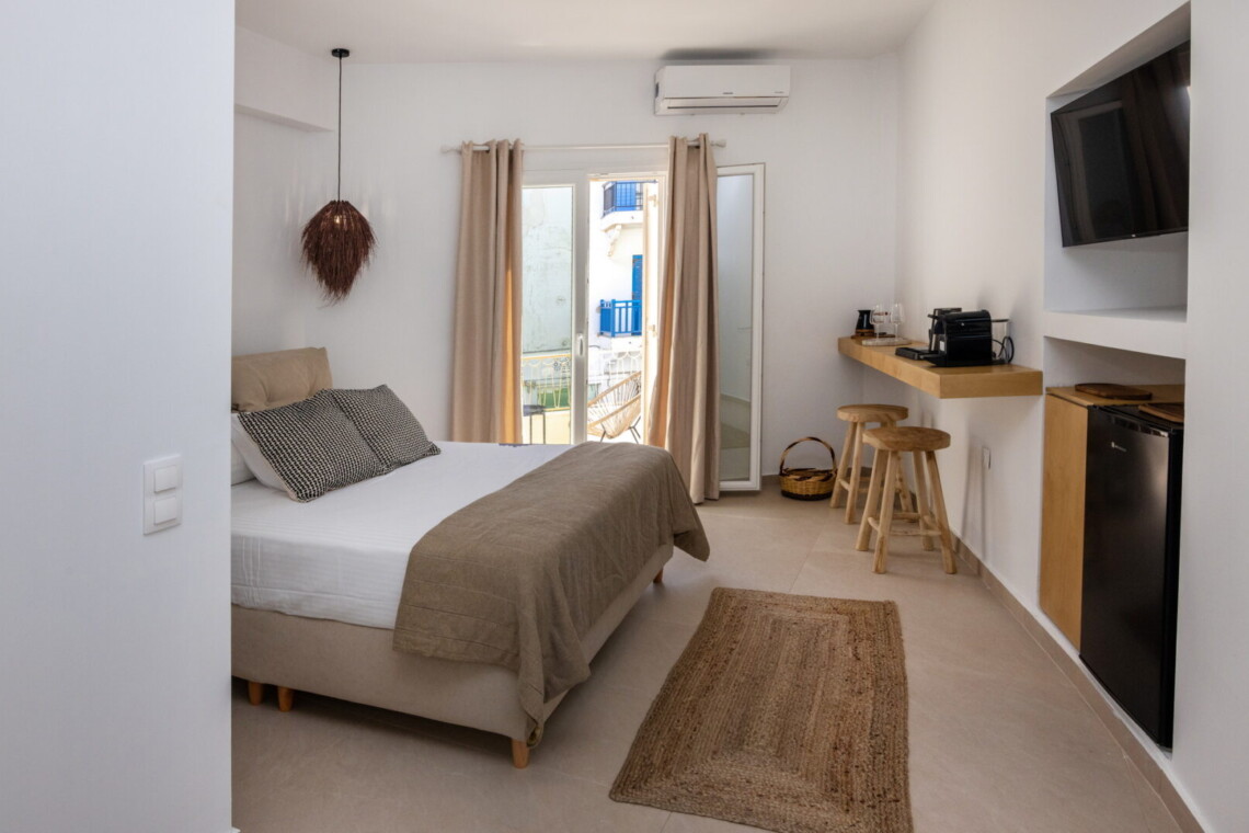 Comfortable queen-size bed in Alora Major Suite, offering a luxurious and restful experience in Tinos Town.