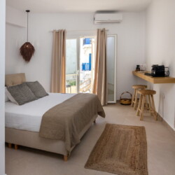 Comfortable queen-size bed in Alora Major Suite, offering a luxurious and restful experience in Tinos Town.