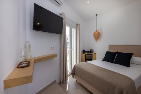 Comfortable queen-size bed in Alora Major Suite, offering a luxurious and restful experience in Tinos Town.