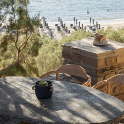 Rabela’s House exterior view at Kolibithra Beach, Tinos Island – beachfront accommodation surrounded by scenic beauty.